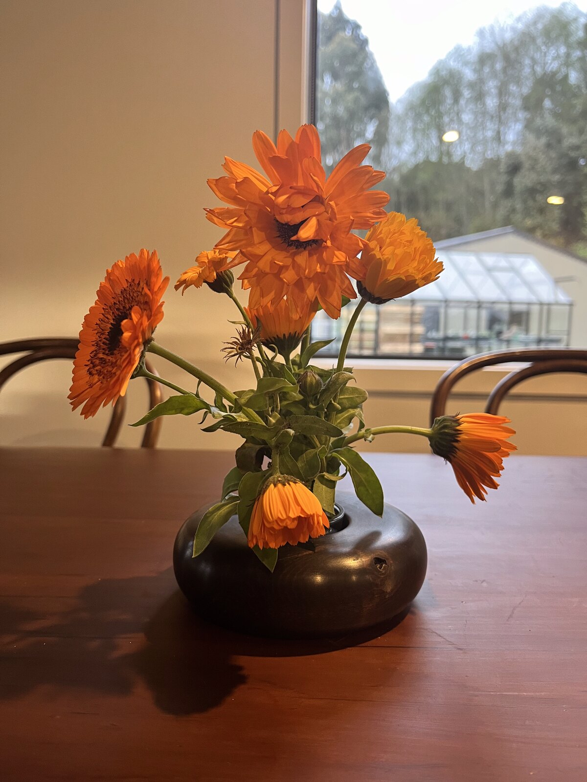Hand-turned vase holding orange flowers